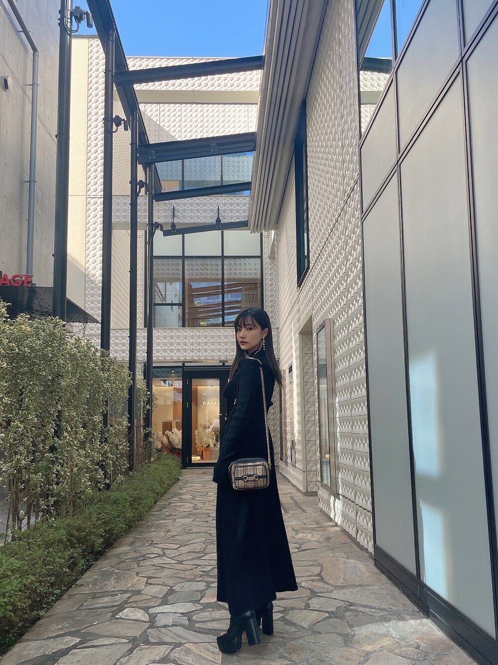 ブラック系のワンピースを着用したレディースの春コーディネートの2枚目の写真