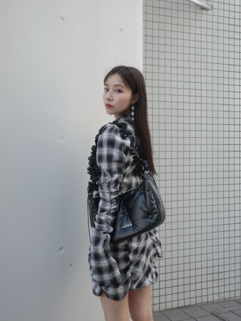 ブラック系のワンピース、ブラック系のローファー、ブラック系のショルダーバッグを着用したレディースの冬コーディネートの3枚目の写真