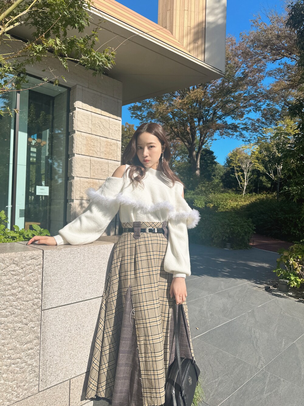 ホワイト系のニット/セーター、ブラック系のショルダーバッグ、イエロー系のスカートを着用したレディースの春コーディネートの3枚目の写真