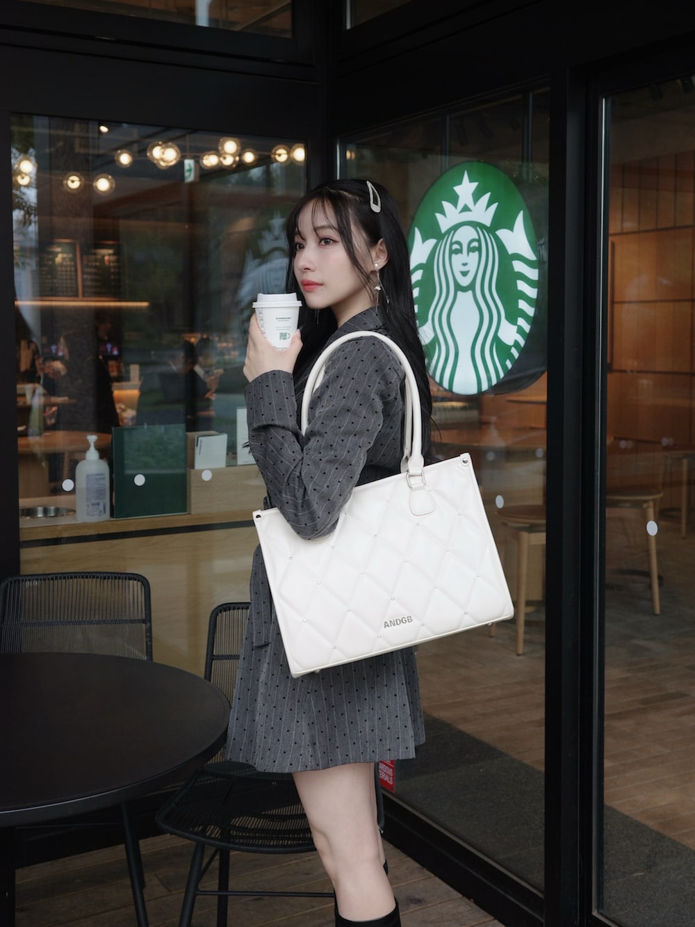 ブラック系のワンピース、ホワイト系のトートバッグを着用したレディースの冬コーディネートの3枚目の写真