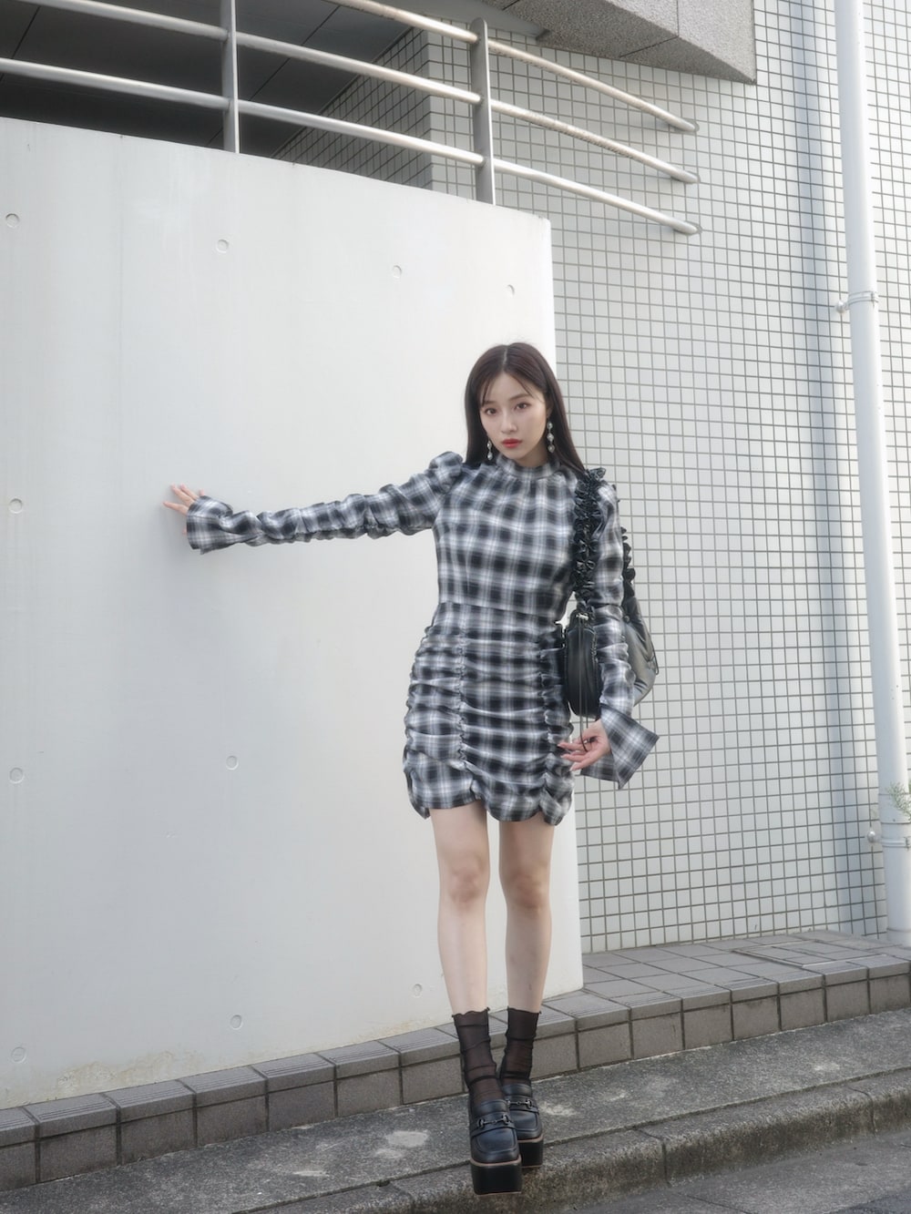 ブラック系のワンピース、ブラック系のローファー、ブラック系のショルダーバッグを着用したレディースの冬コーディネートの2枚目の写真