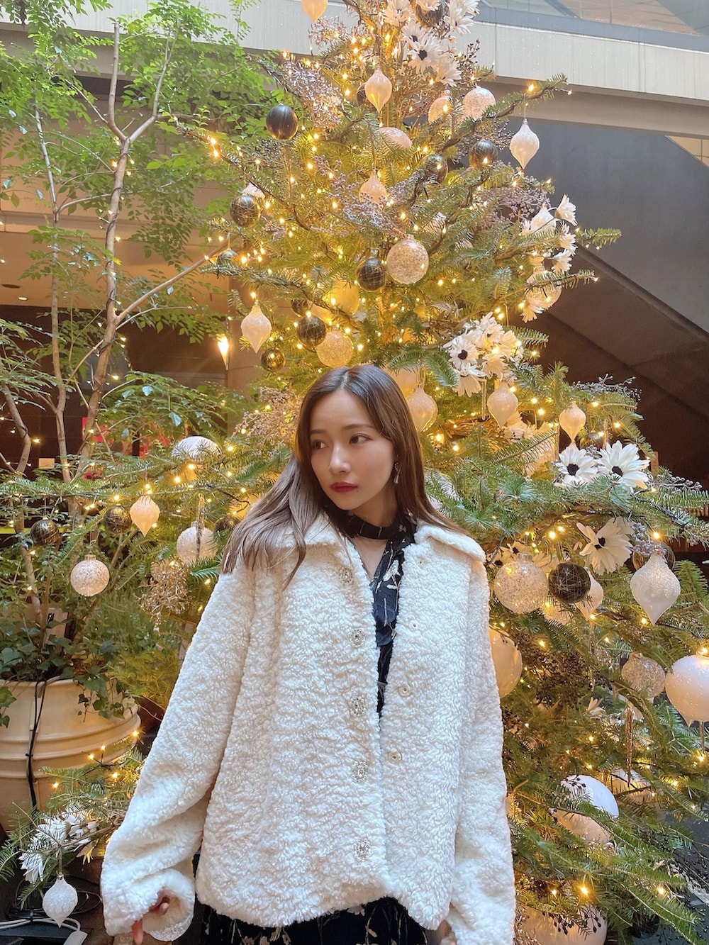 ブラック系のワンピース、ホワイト系のダウンジャケット/コートを着用したレディースの春コーディネートの4枚目の写真