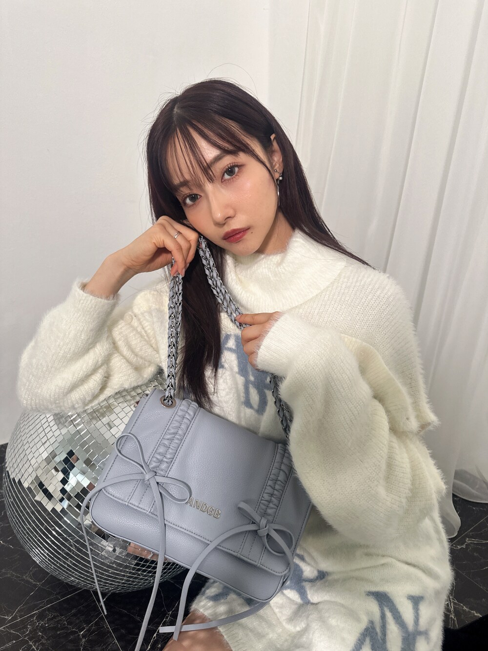 ホワイト系のワンピース、ブルー系のショルダーバッグを着用したレディースの冬コーディネートの3枚目の写真