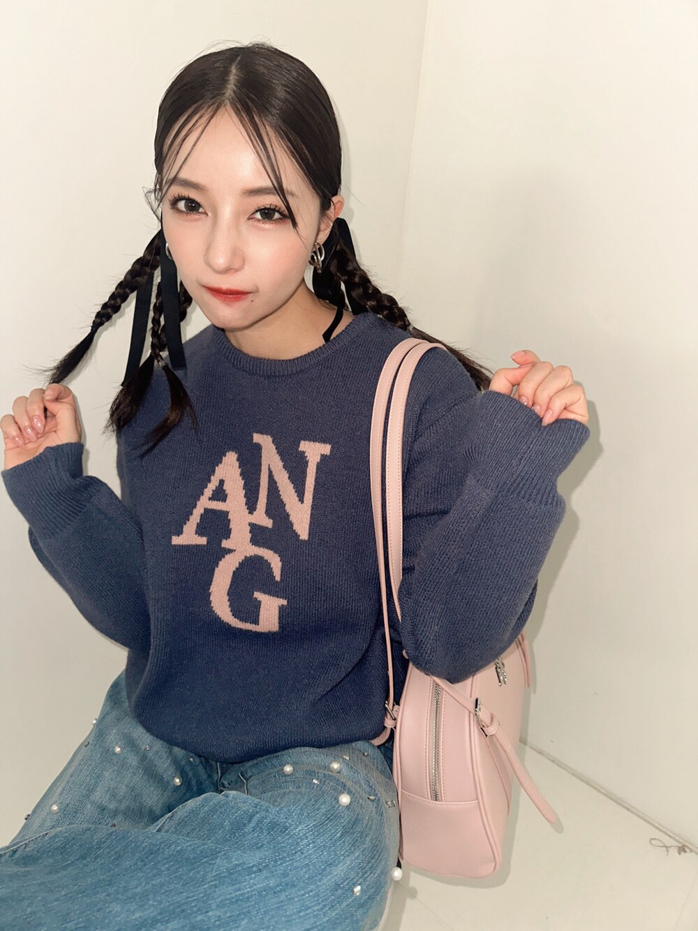 ブルー系のニット/セーター、ブラック系のショルダーバッグ、ブルー系のデニムパンツを着用したレディースの冬コーディネートの2枚目の写真