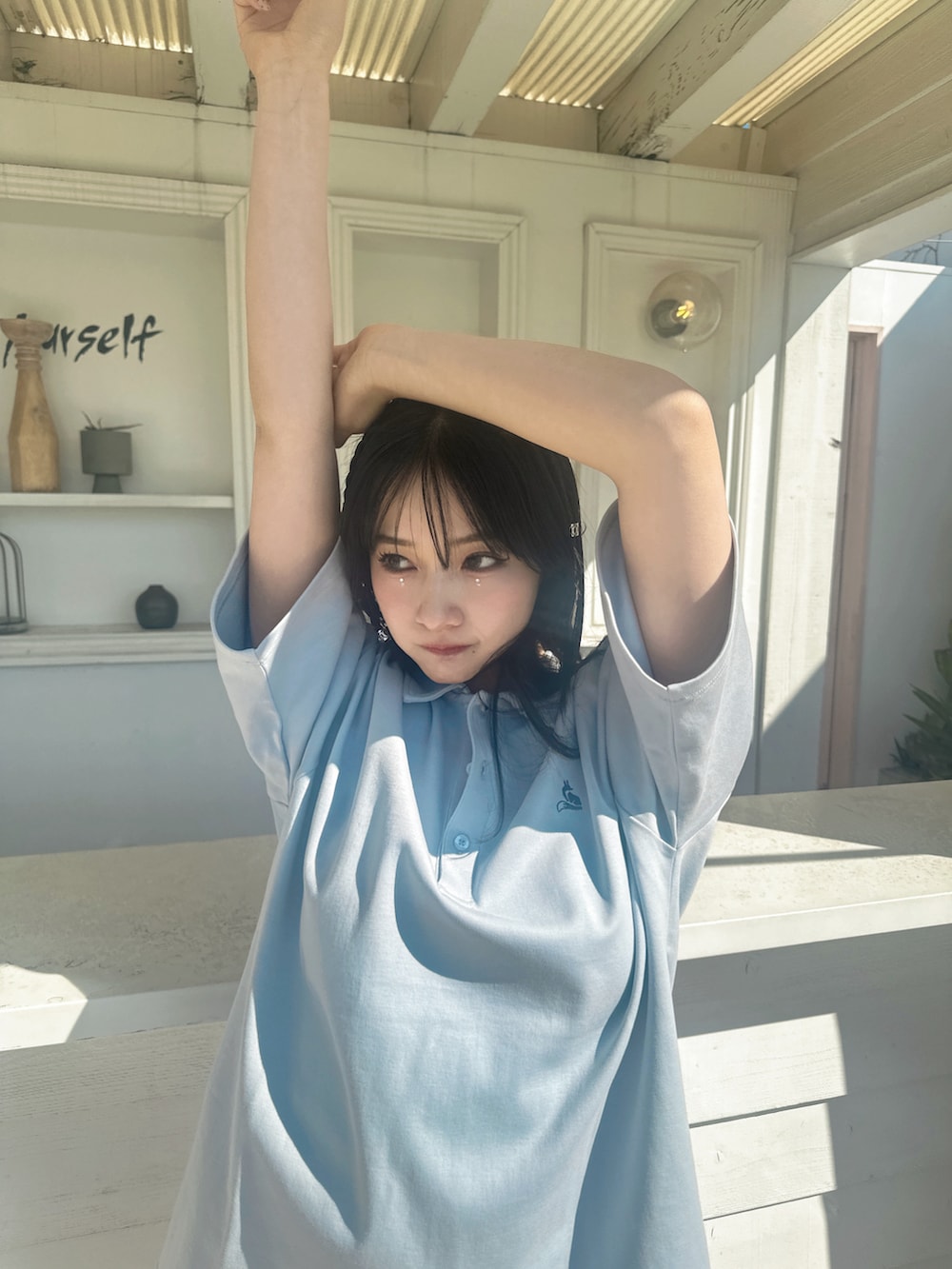 ブルー系のポロシャツを着用したレディースの春コーディネートの3枚目の写真