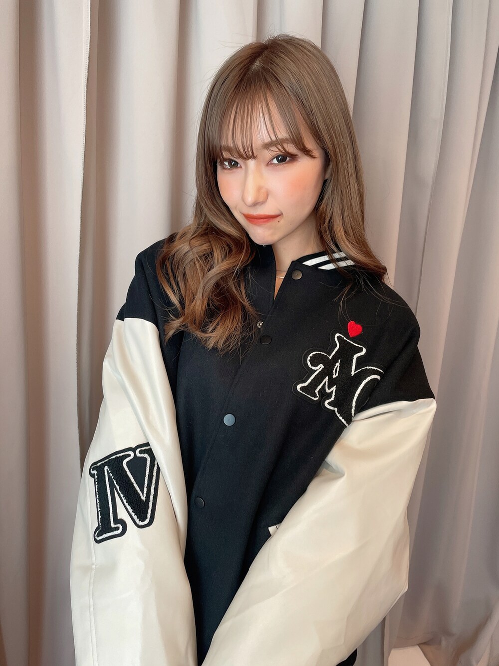 ホワイト系のスタジャンを着用したレディースの冬コーディネートの2枚目の写真