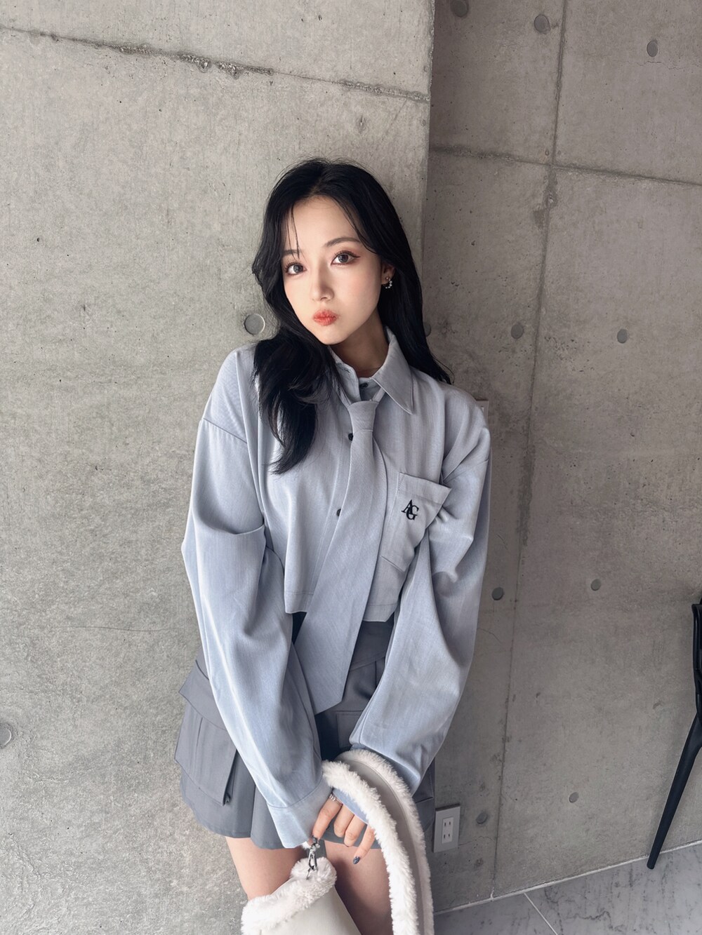 ブルー系のシャツ/ブラウス、グレー系のスカート、ホワイト系のショルダーバッグを着用したレディースの秋コーディネートの4枚目の写真