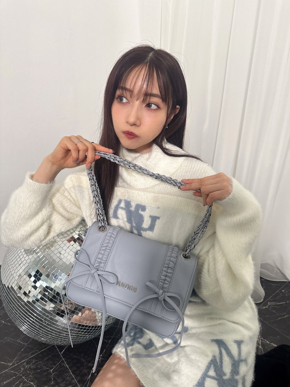 ホワイト系のワンピース、ブルー系のショルダーバッグを着用したレディースの冬コーディネートの4枚目の写真