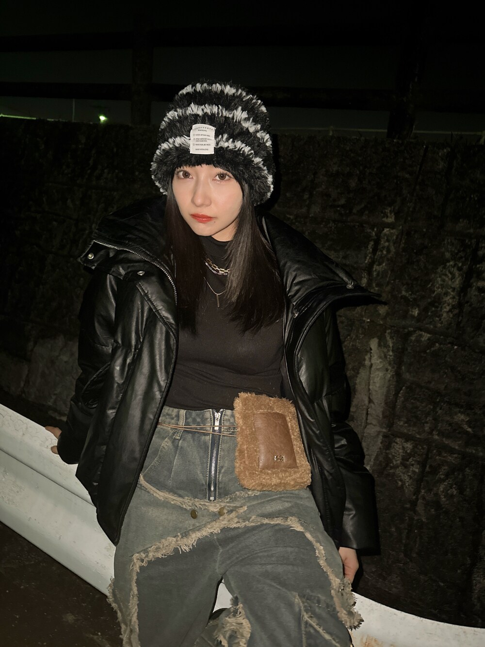 ブラック系のニットキャップ/ビーニーを着用したレディースの春コーディネートの3枚目の写真