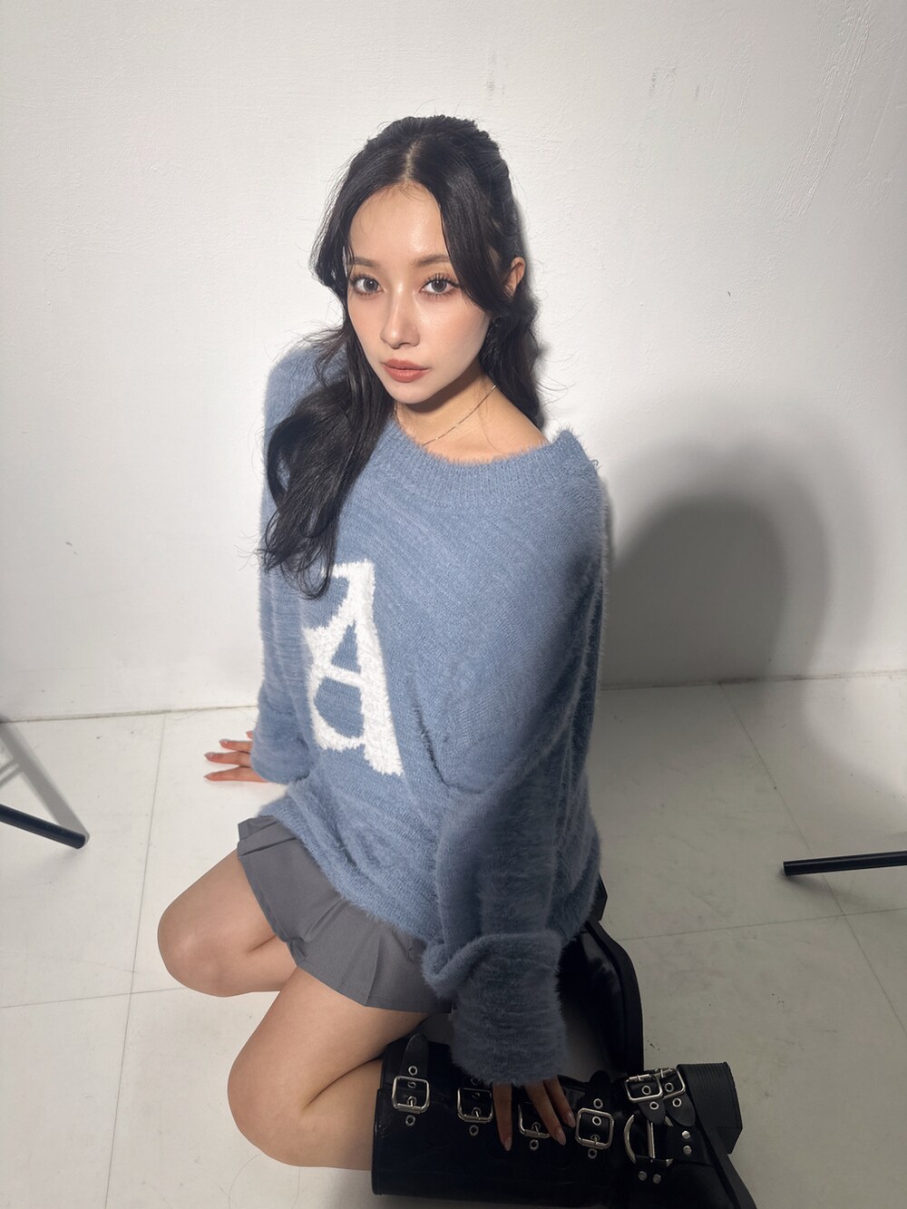 ブルー系のニット/セーター、グレー系のスカートを着用したレディースの冬コーディネートの2枚目の写真