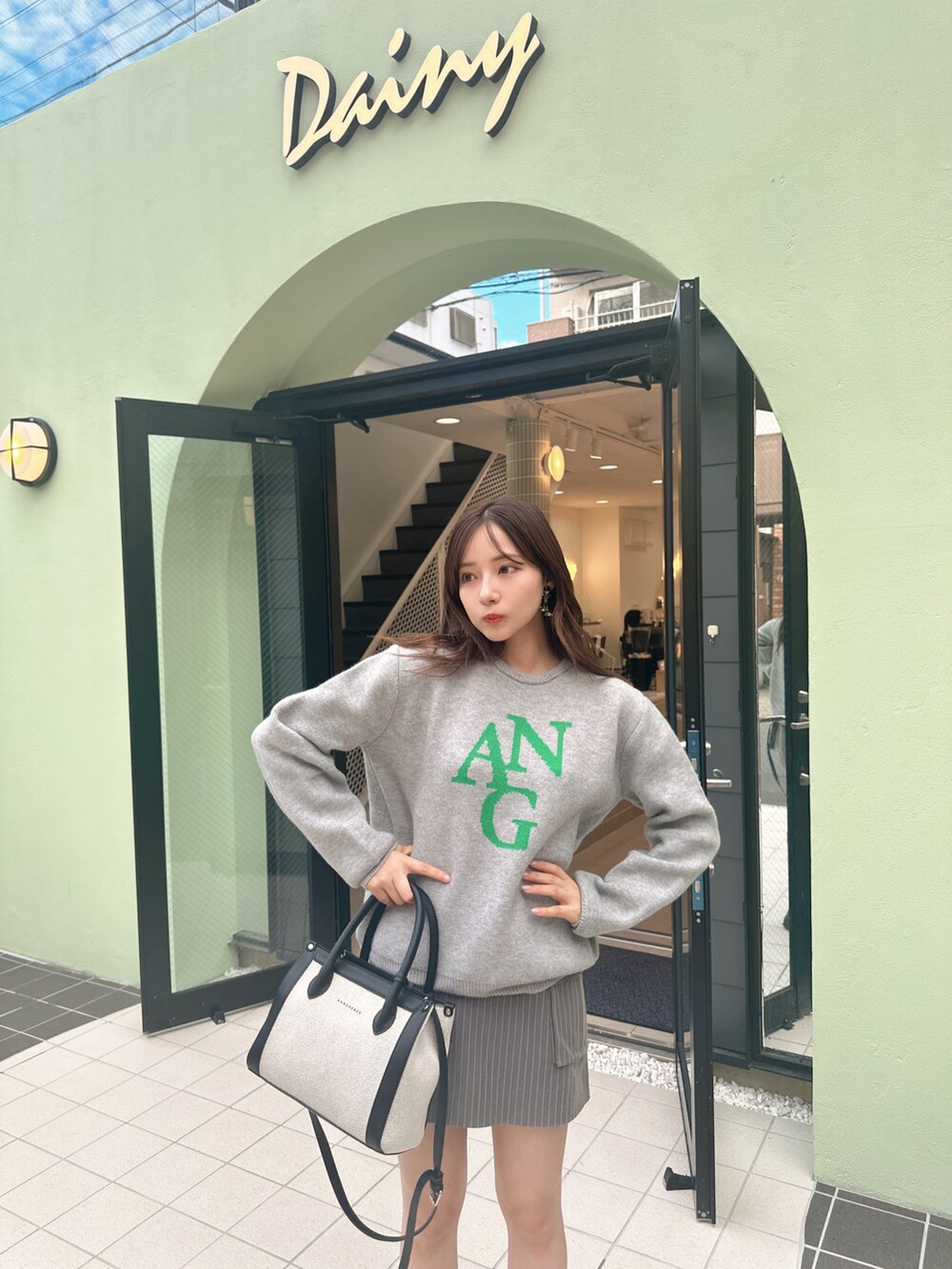 ブルー系のニット/セーター、ブラック系のショルダーバッグを着用したレディースの冬コーディネートの4枚目の写真