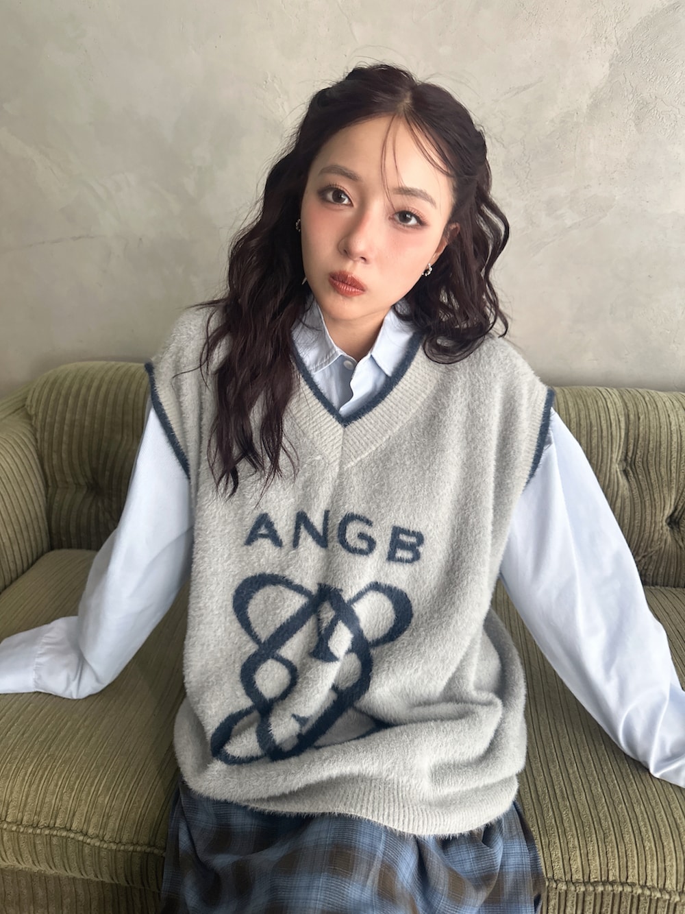 グレー系のベスト、ブルー系のスカート、ホワイト系のシャツ/ブラウスを着用したレディースの秋コーディネートの3枚目の写真