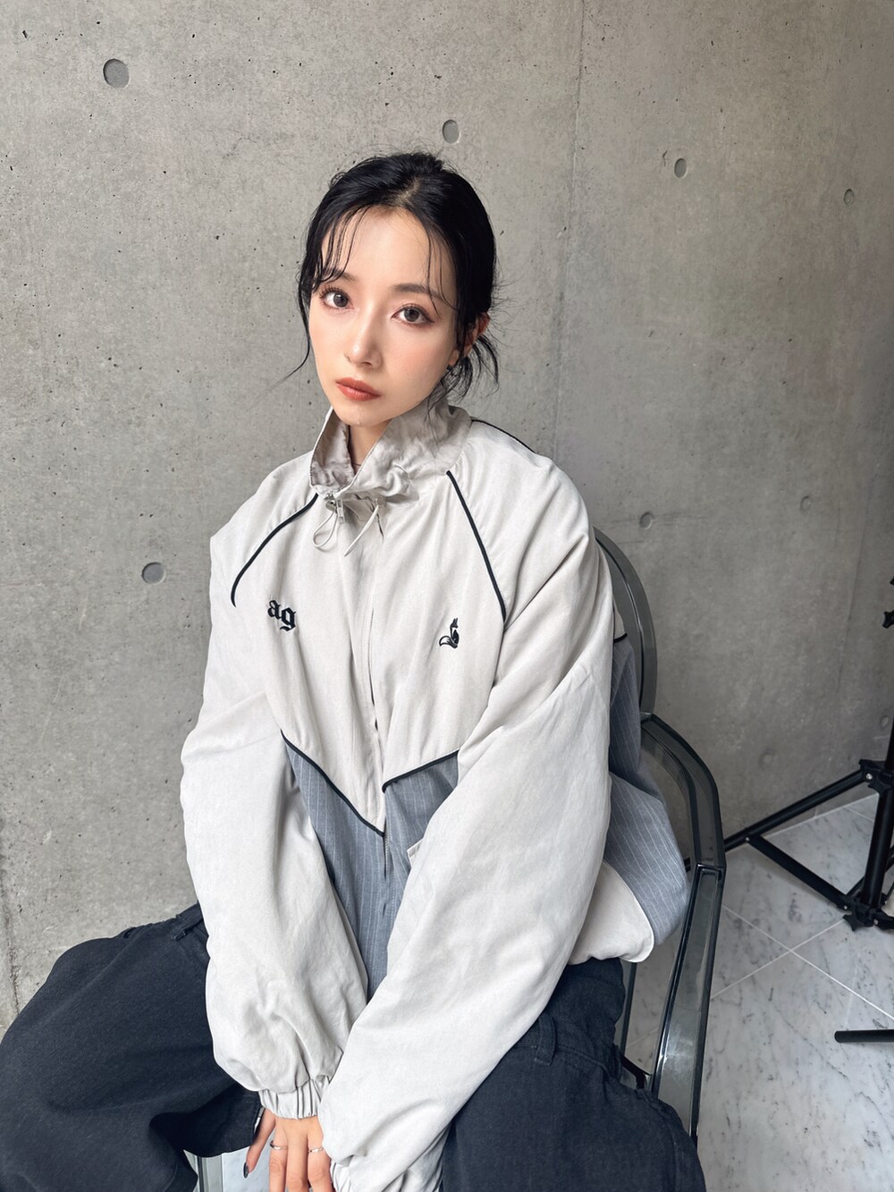 グレー系のブルゾンを着用したレディースの秋コーディネートの2枚目の写真