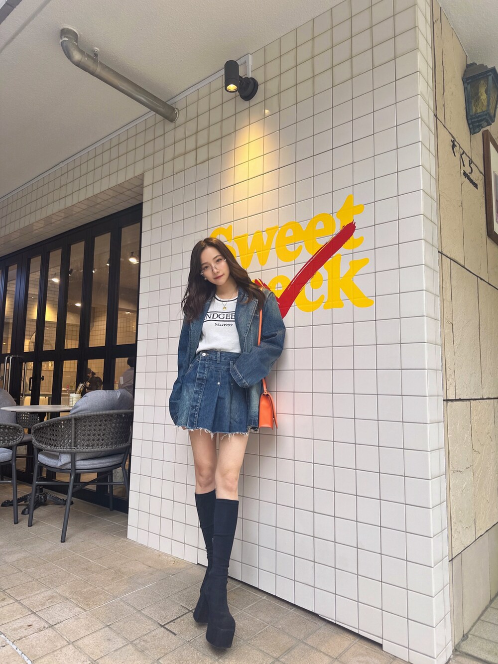 ブルー系のニット/セーター、ブルー系のデニムジャケット、ブルー系のスカートを着用したレディースの夏コーディネートの2枚目の写真