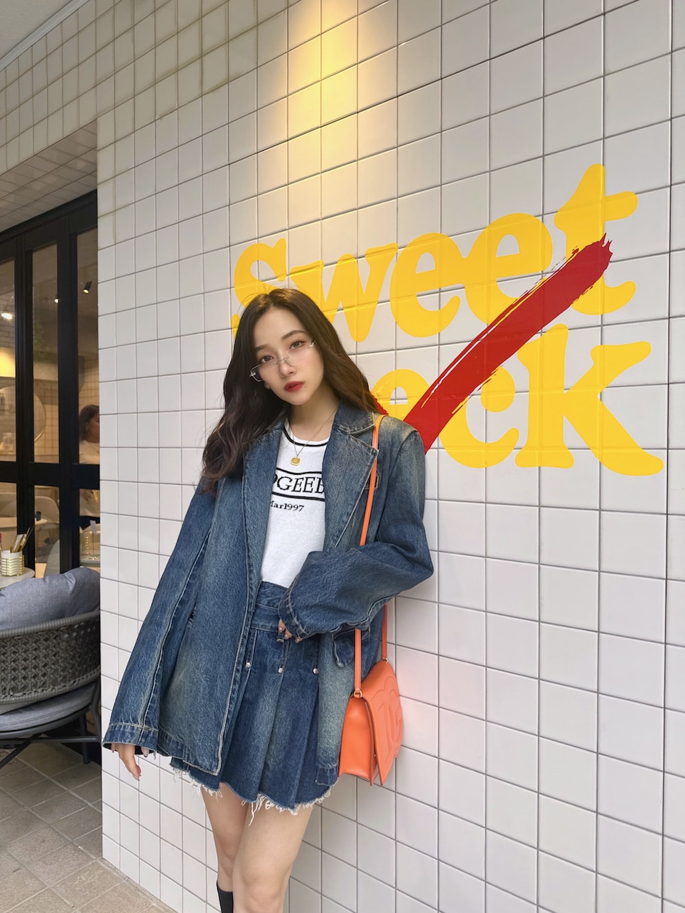 ブルー系のニット/セーター、ブルー系のデニムジャケット、ブルー系のスカートを着用したレディースの夏コーディネートの4枚目の写真