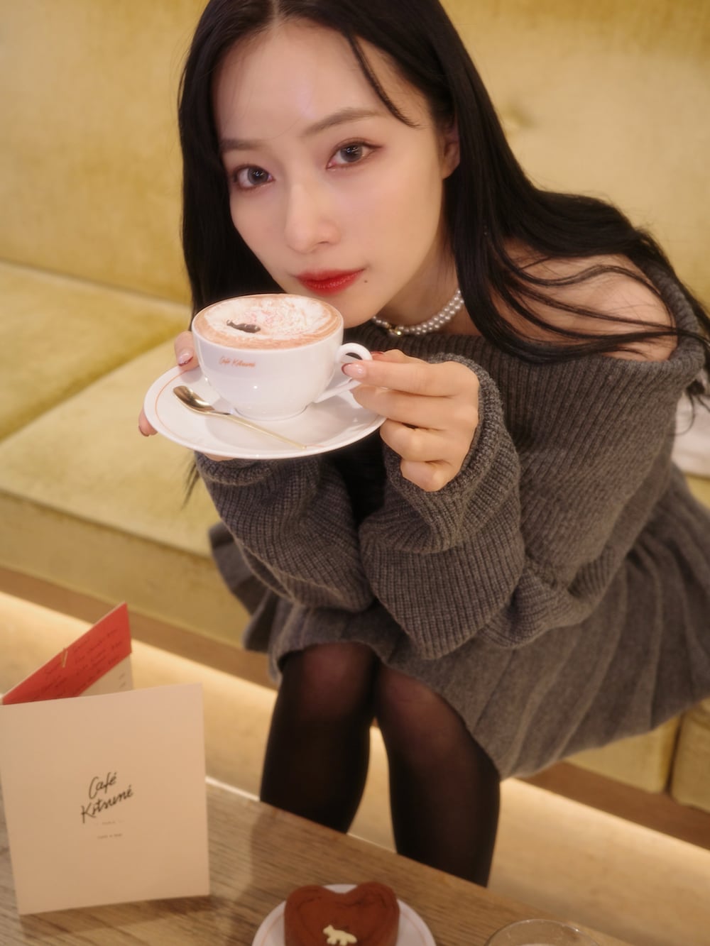 グレー系のワンピース、ブラック系のショルダーバッグを着用したレディースの春コーディネートの2枚目の写真