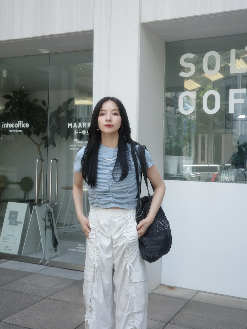 ブラック系のトートバッグ、ベージュ系のカーゴパンツ、ブルー系のTシャツ/カットソーを着用したレディースの秋コーディネートの5枚目の写真