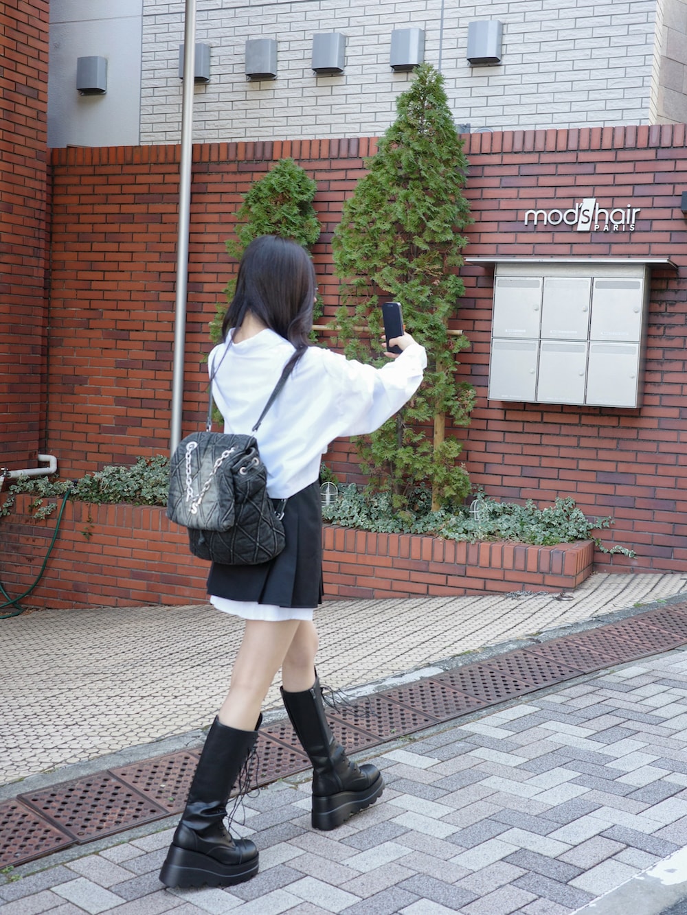 ホワイト系のシャツ/ブラウス、グレー系のスカートを着用したレディースの夏コーディネートの2枚目の写真