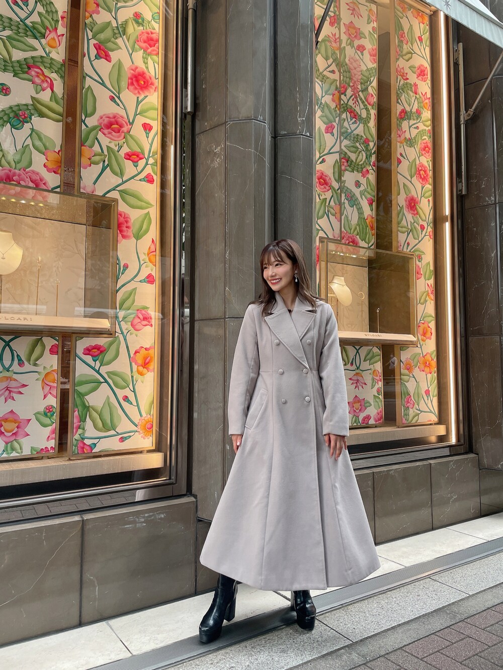 グレー系のチェスターコート、ブラック系のブーツを着用したレディースの冬コーディネートの3枚目の写真