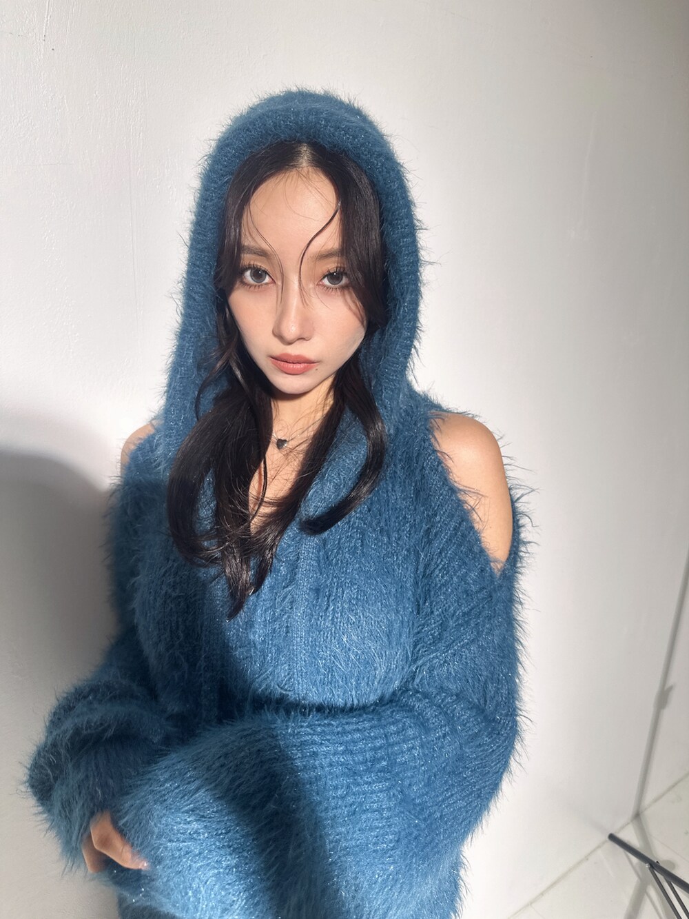 ブルー系のニット/セーターを着用したレディースの冬コーディネートの2枚目の写真