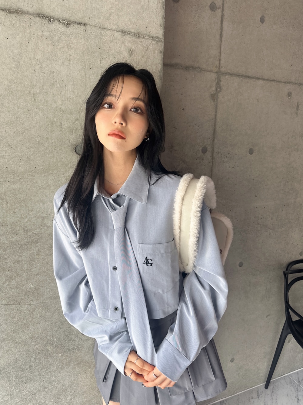 ブルー系のシャツ/ブラウス、グレー系のスカート、ホワイト系のショルダーバッグを着用したレディースの秋コーディネートの2枚目の写真