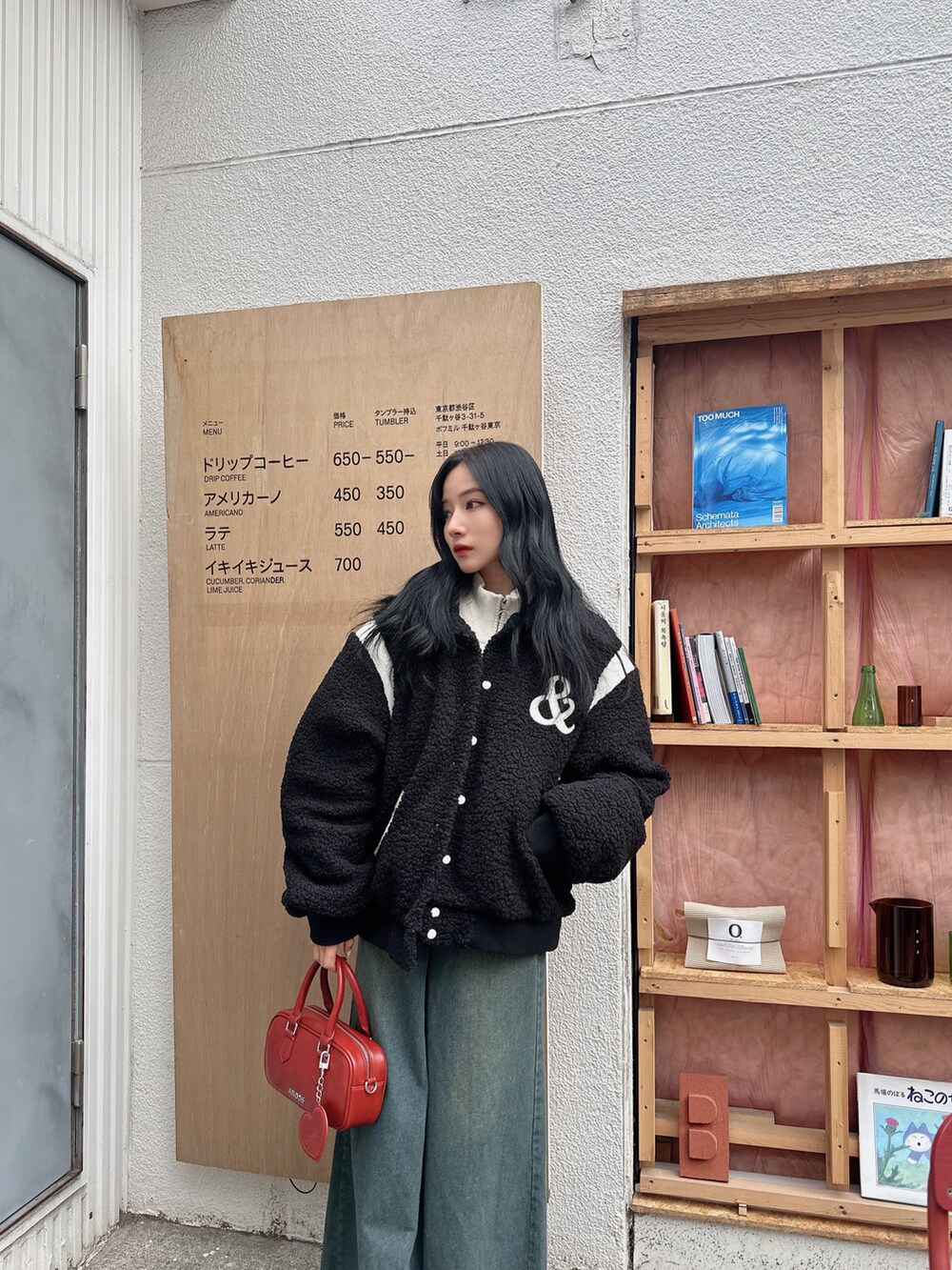 ブラック系のスタジャン、レッド系のショルダーバッグを着用したレディースの春コーディネートの4枚目の写真