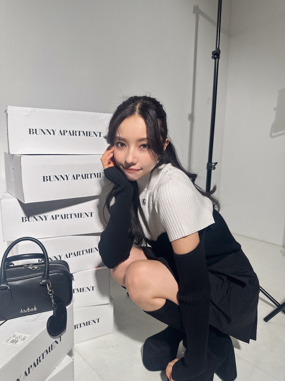 ホワイト系のニット/セーター、ブラック系のスカート、ブラック系のショルダーバッグを着用したレディースの冬コーディネートの4枚目の写真