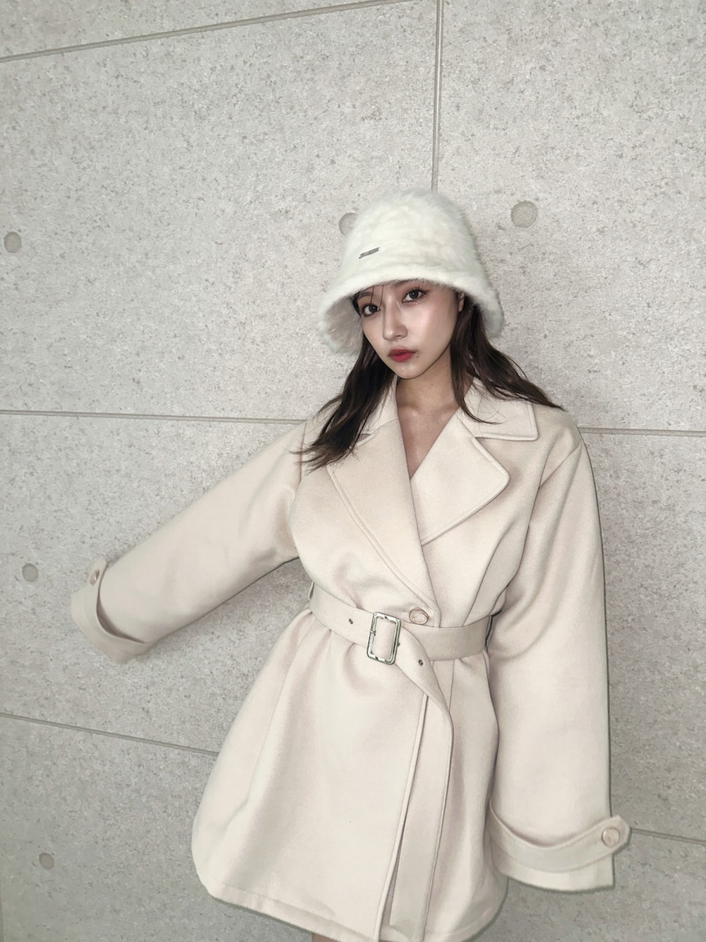 ベージュ系のダウンジャケット/コート、ホワイト系のハットを着用したレディースの冬コーディネートの2枚目の写真