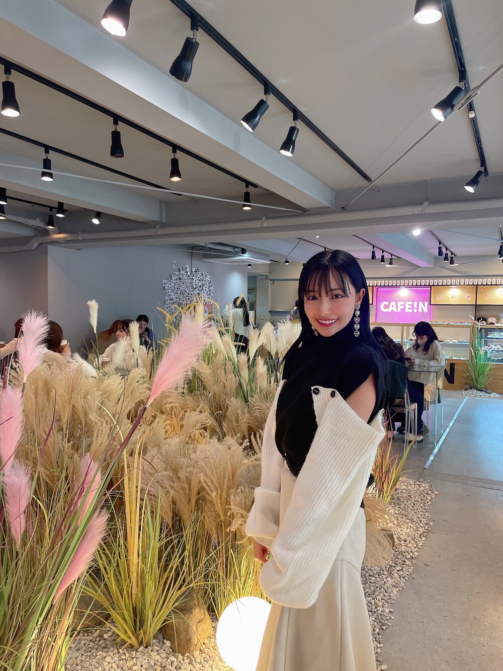 ブラック系のニット/セーター、ホワイト系のスカートを着用したレディースの春コーディネートの3枚目の写真