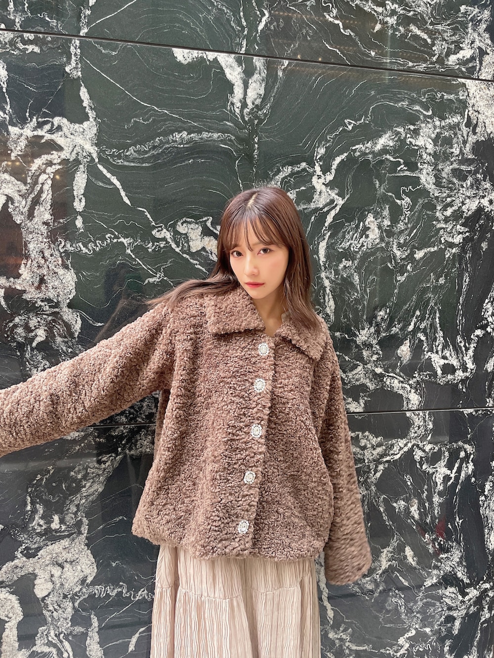 ブラウン系のダウンジャケット/コート、ブラック系のワンピースを着用したレディースの冬コーディネートの4枚目の写真