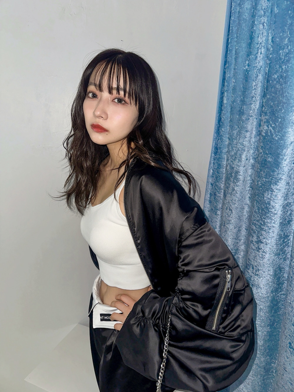 ブラック系のブルゾン、ブラック系のカーゴパンツ、ホワイト系のショルダーバッグを着用したレディースの春コーディネートの2枚目の写真