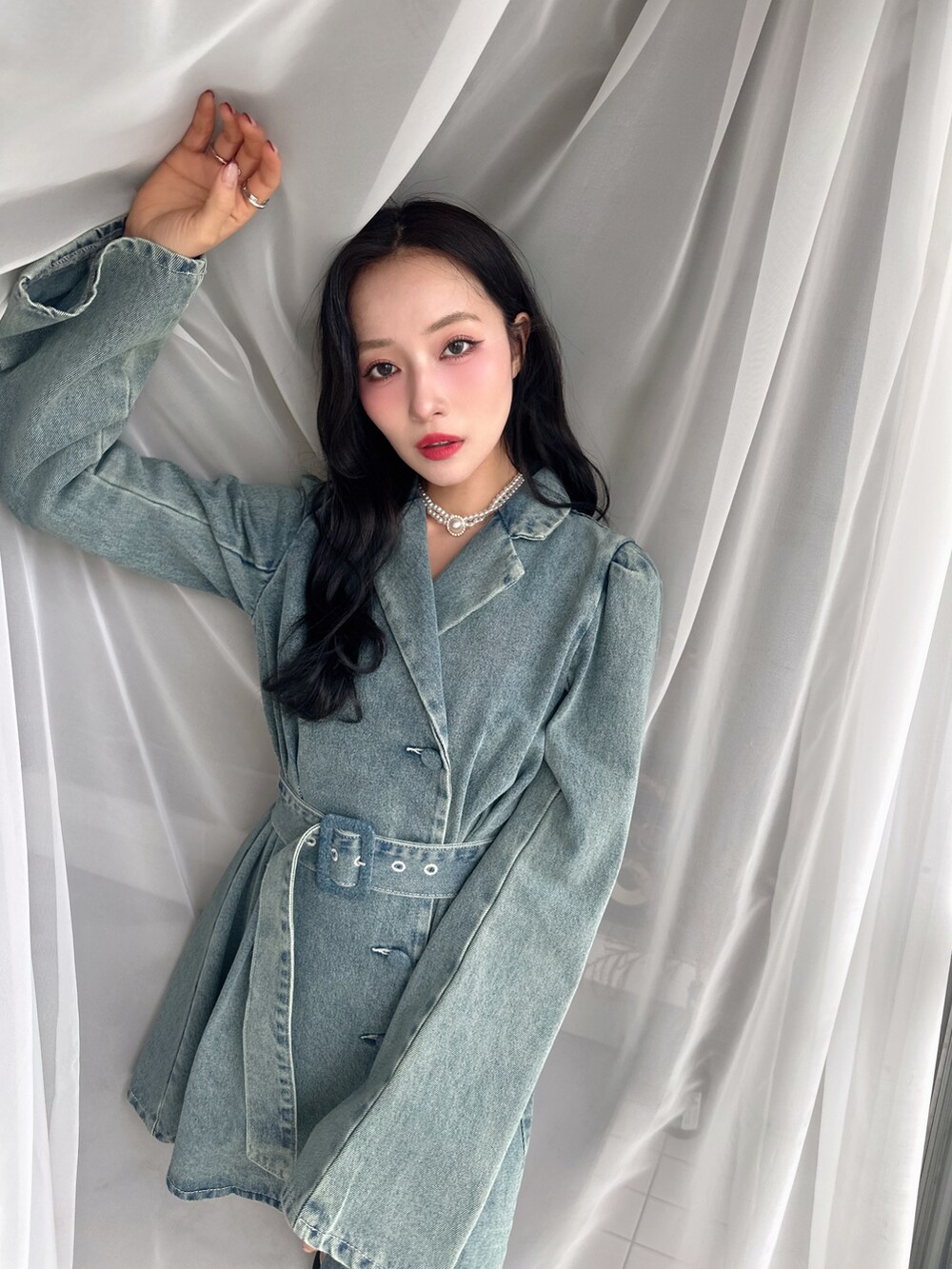 ブルー系のワンピースを着用したレディースの春コーディネートの2枚目の写真