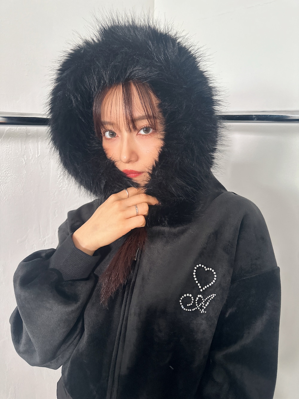 ブラック系のパーカー、ブラック系のスカートを着用したレディースの冬コーディネートの4枚目の写真