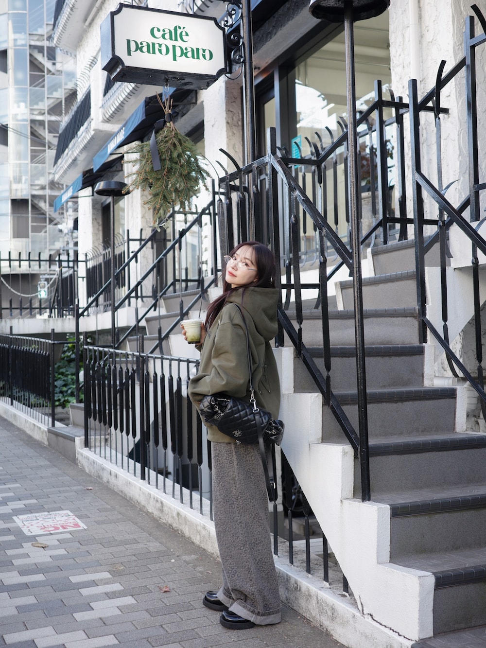 グリーン系のパーカーを着用したレディースの春コーディネートの2枚目の写真