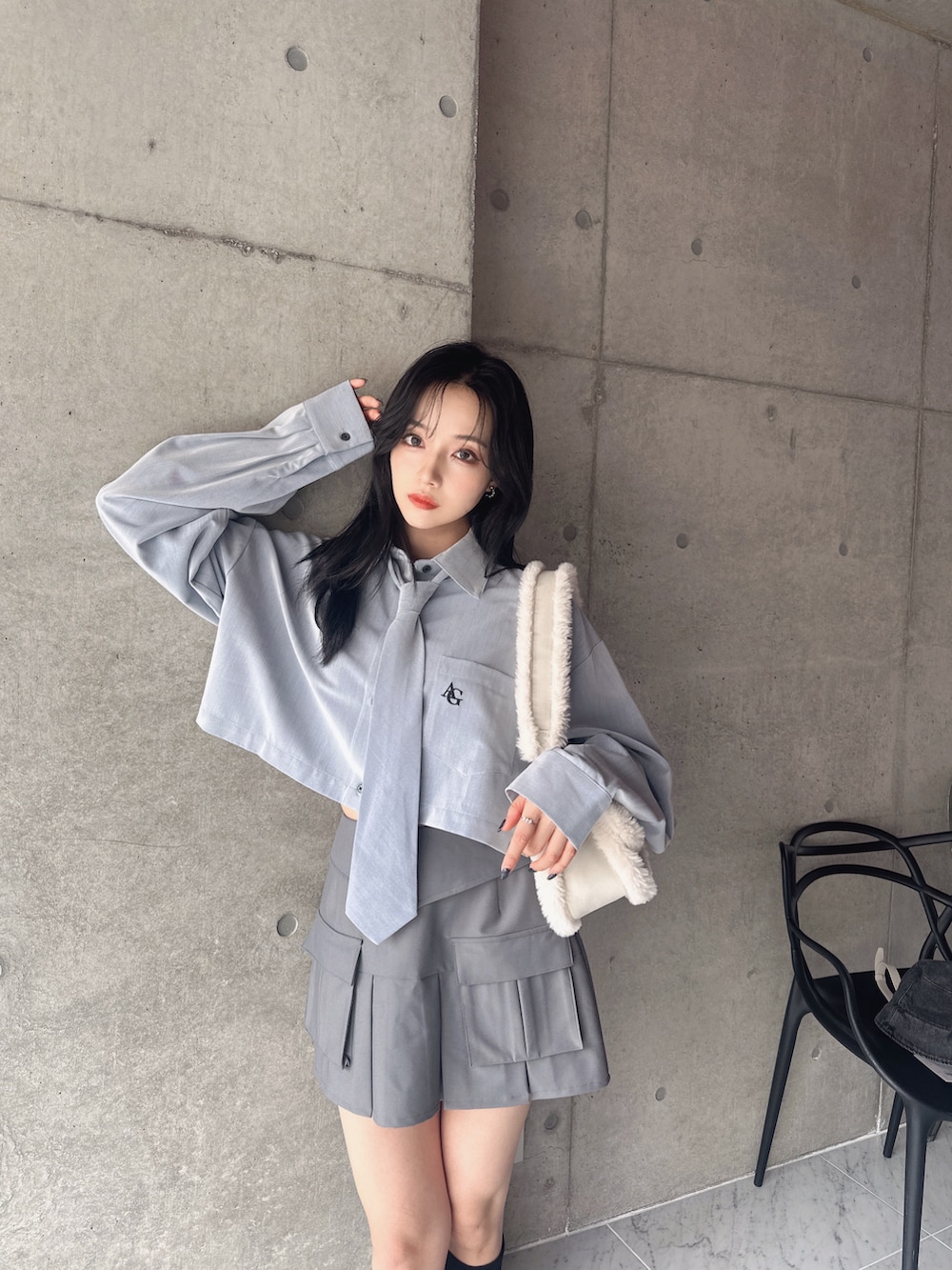 ブルー系のシャツ/ブラウス、グレー系のスカート、ホワイト系のショルダーバッグを着用したレディースの秋コーディネートの2枚目の写真