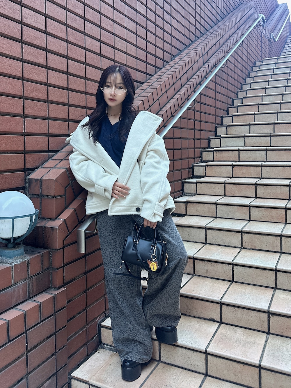 ブラック系のトートバッグを着用したレディースの冬コーディネートの2枚目の写真