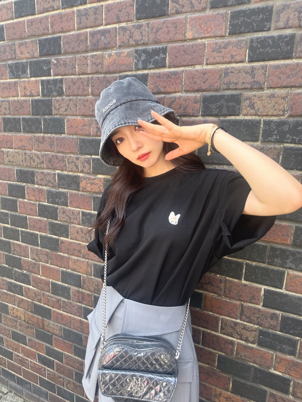 ブラック系のTシャツ/カットソー、ブラック系のショルダーバッグ、グレー系のスカートを着用したレディースの秋コーディネートの3枚目の写真