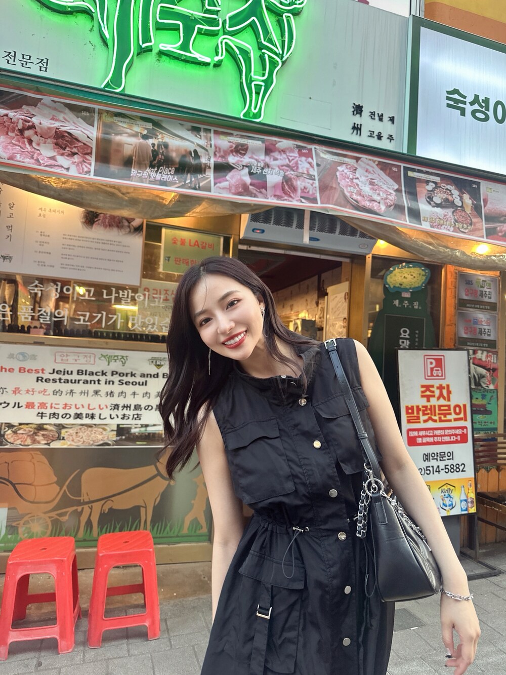 ブラック系のワンピース、ブラック系のショルダーバッグを着用したレディースの秋コーディネートの2枚目の写真