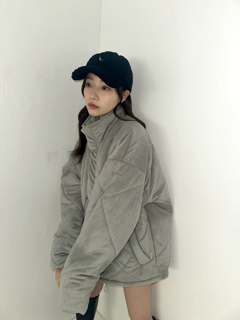グレー系のダウンジャケット/コート、ブラック系のキャップを着用したレディースの春コーディネートの2枚目の写真