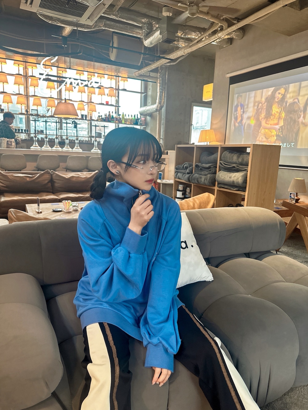 ブルー系のスウェット、ブラック系のパンツを着用したレディースの夏コーディネートの3枚目の写真