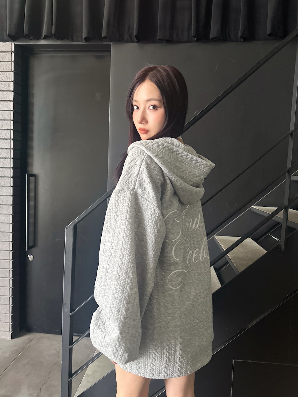 グレー系のパーカーを着用したレディースの秋コーディネートの4枚目の写真