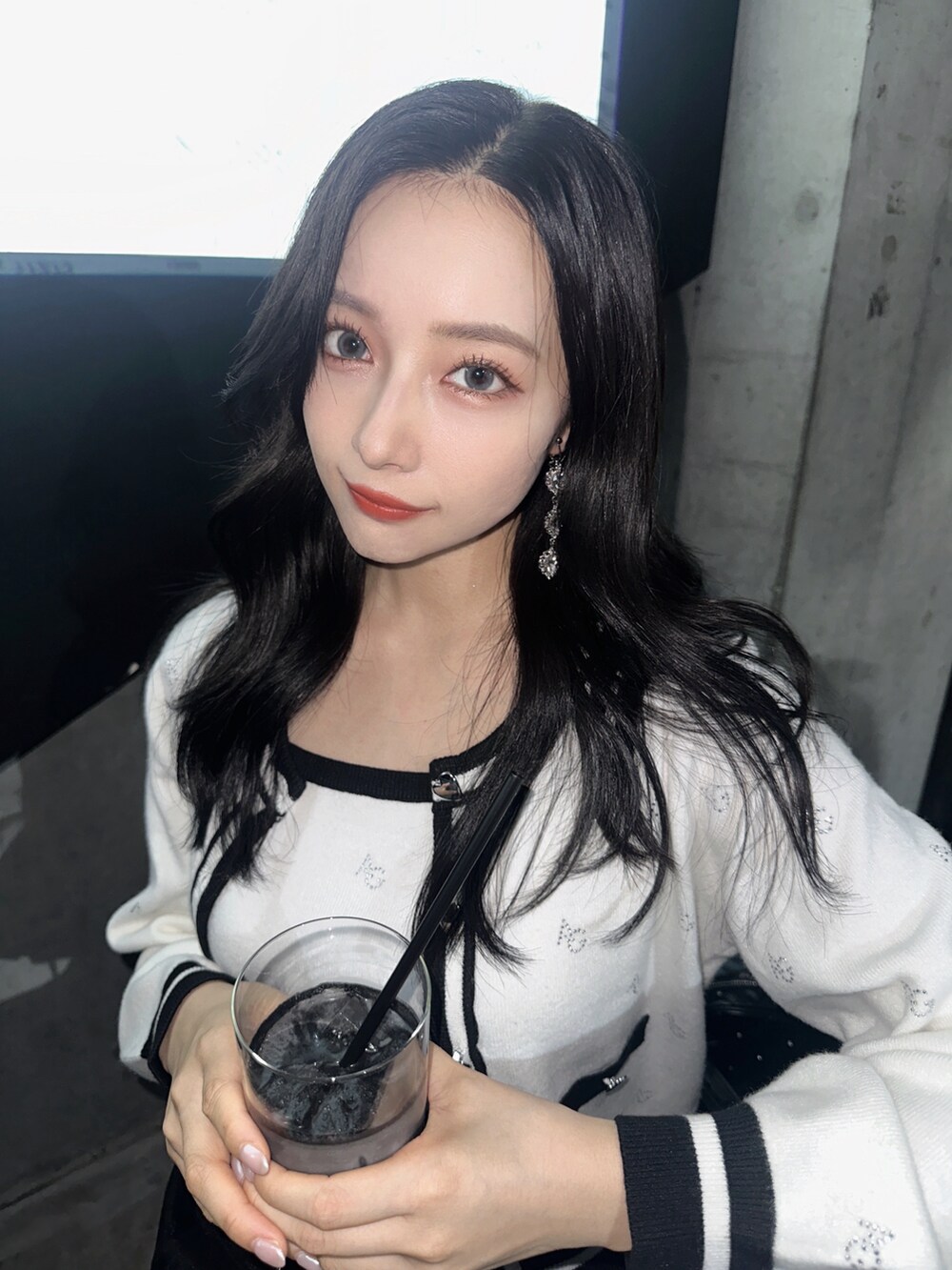 ホワイト系のアンサンブル、グレー系のショルダーバッグ、ブラック系のスカートを着用したレディースの秋コーディネートの3枚目の写真