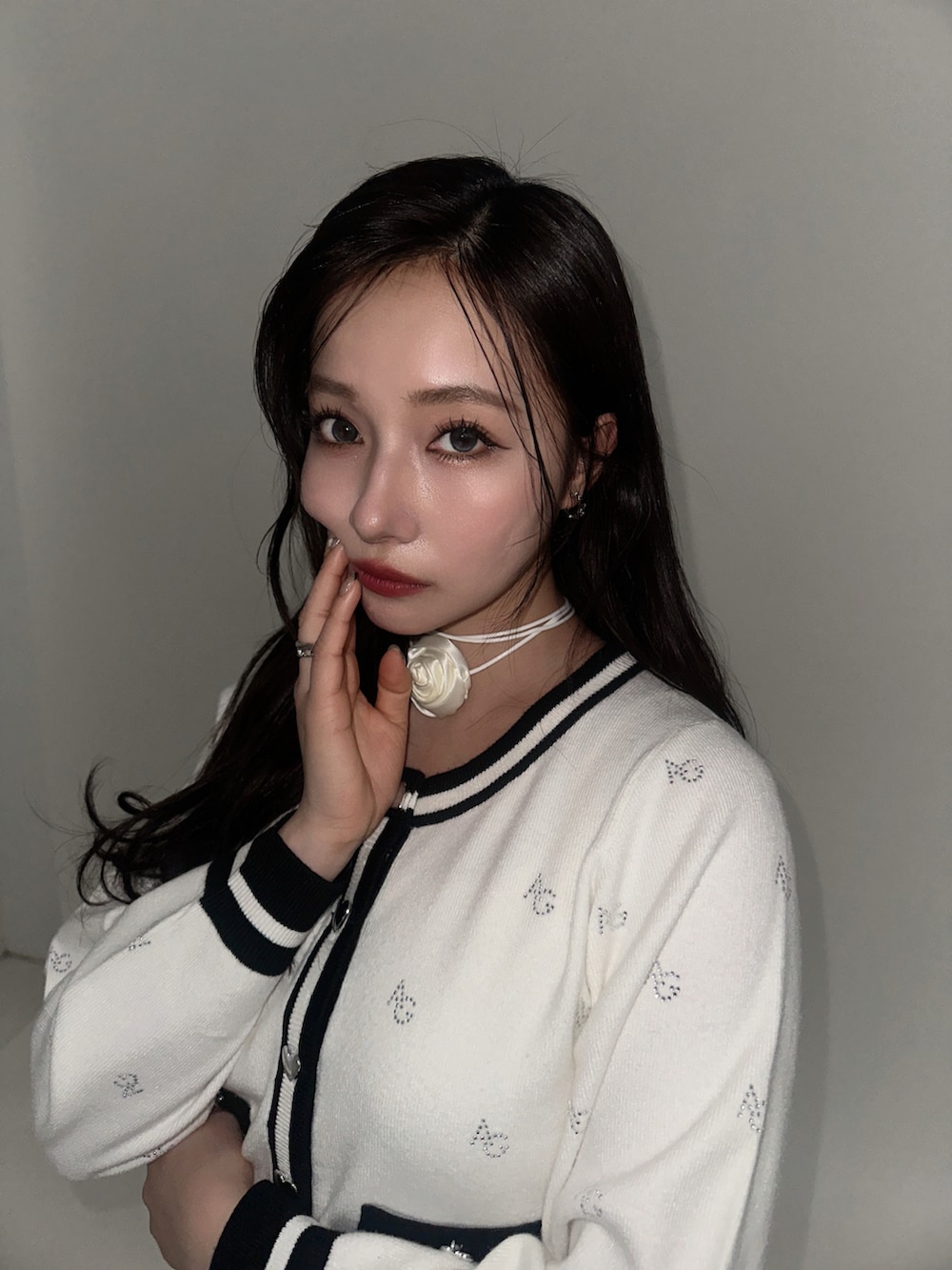 ホワイト系のアンサンブル、グレー系のスカートを着用したレディースの冬コーディネートの3枚目の写真