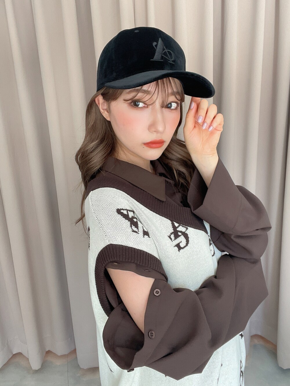 ホワイト系のベスト、ブラウン系のシャツ/ブラウス、ブラック系のキャップを着用したレディースの秋コーディネートの2枚目の写真