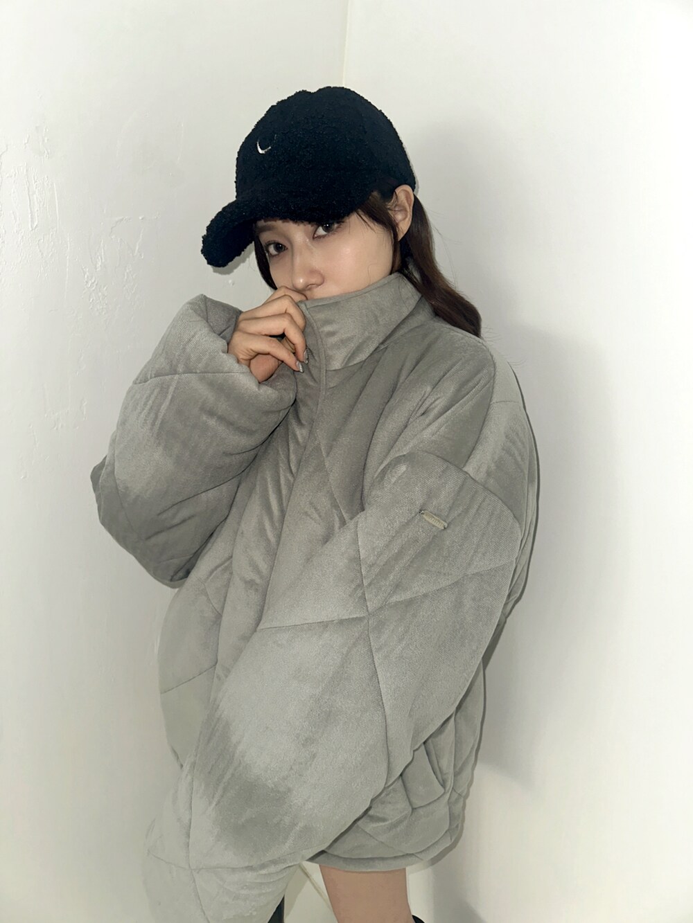 グレー系のダウンジャケット/コート、ブラック系のキャップを着用したレディースの春コーディネートの3枚目の写真