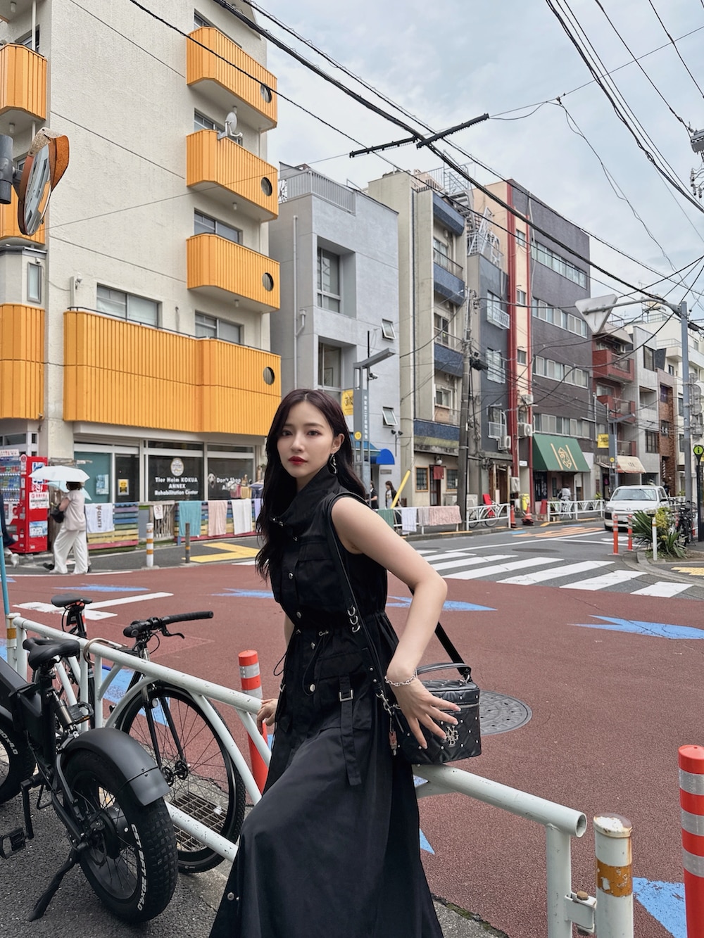ブラック系のワンピース、パープル系のショルダーバッグを着用したレディースの秋コーディネートの3枚目の写真