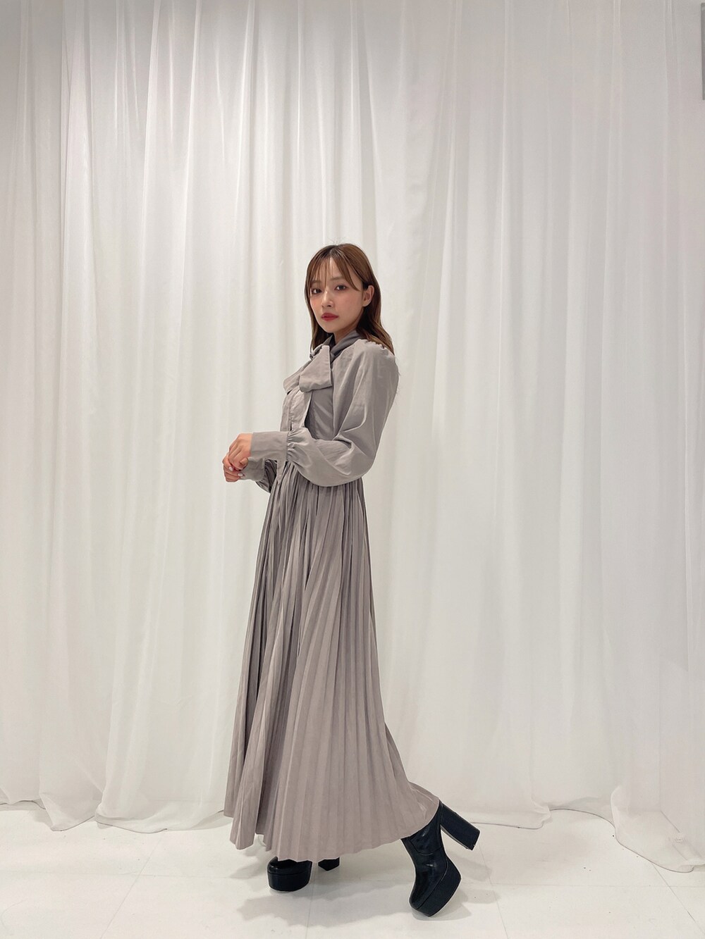 ブラック系のブーツ、グレー系のワンピースを着用したレディースの冬コーディネートの3枚目の写真