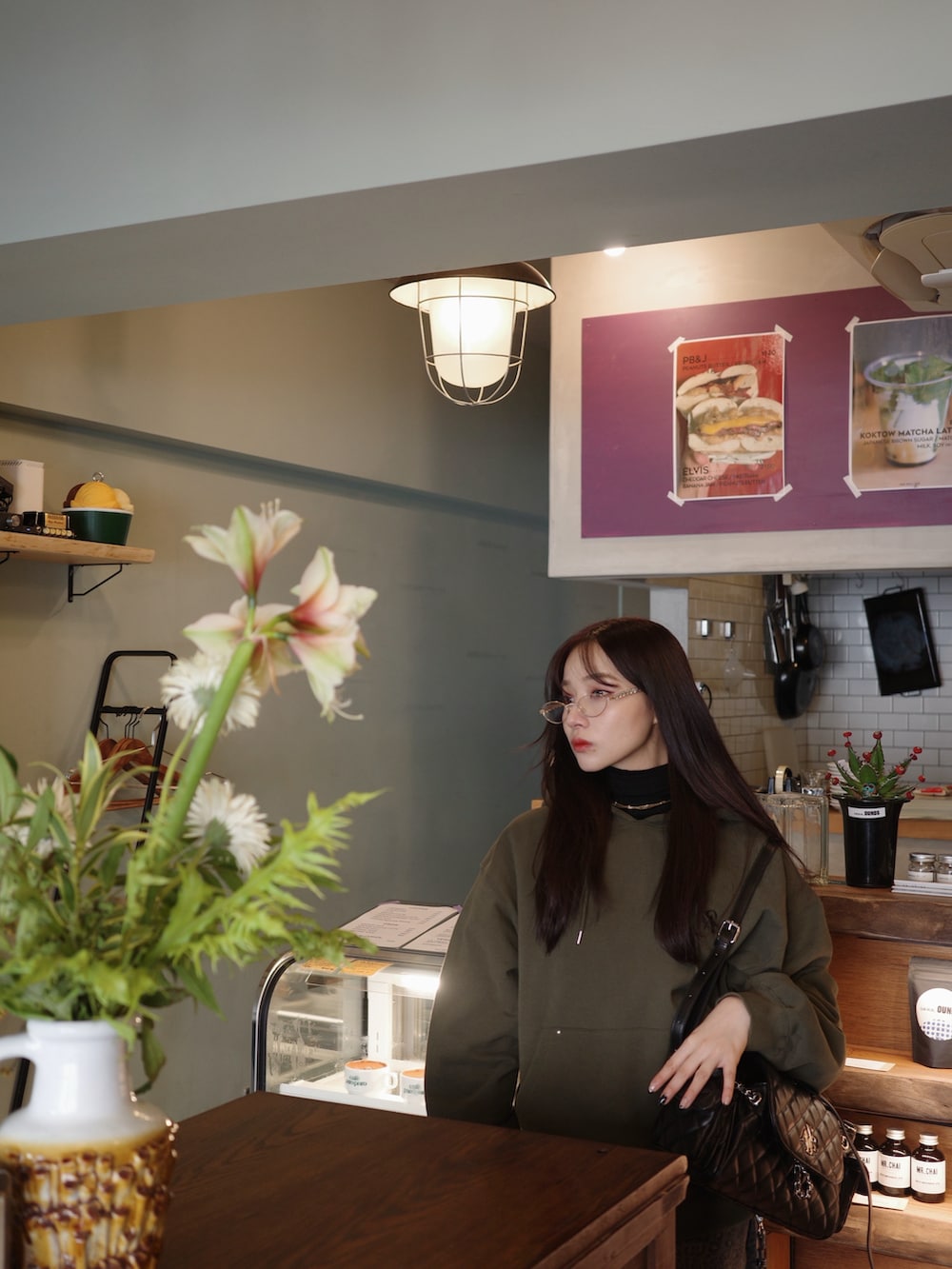 グリーン系のパーカーを着用したレディースの冬コーディネートの3枚目の写真