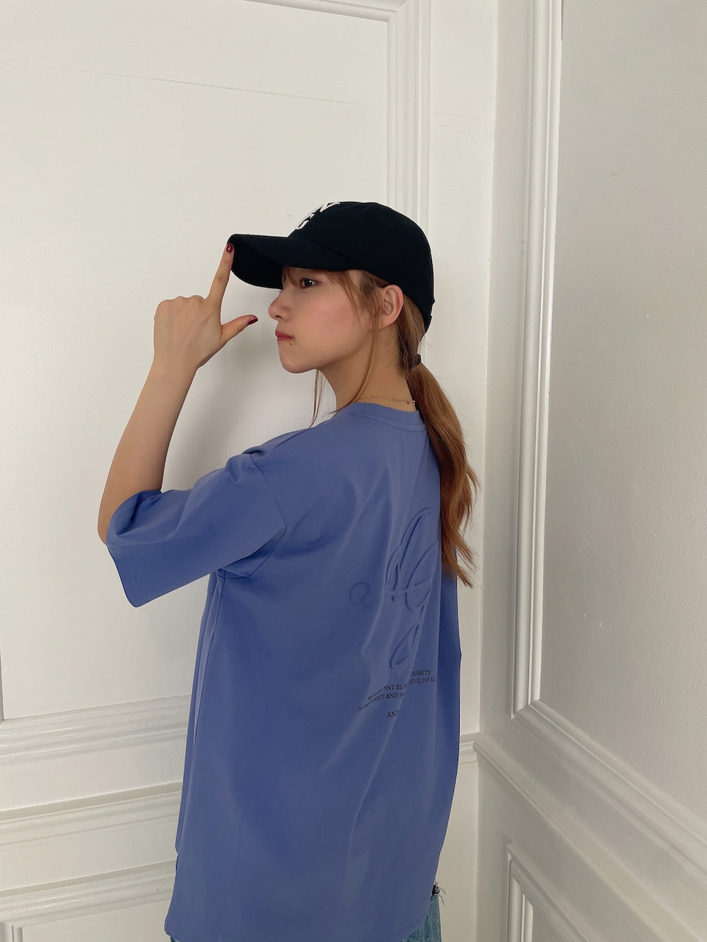 パープル系のTシャツ/カットソー、ブラック系のキャップを着用したレディースの秋コーディネートの2枚目の写真