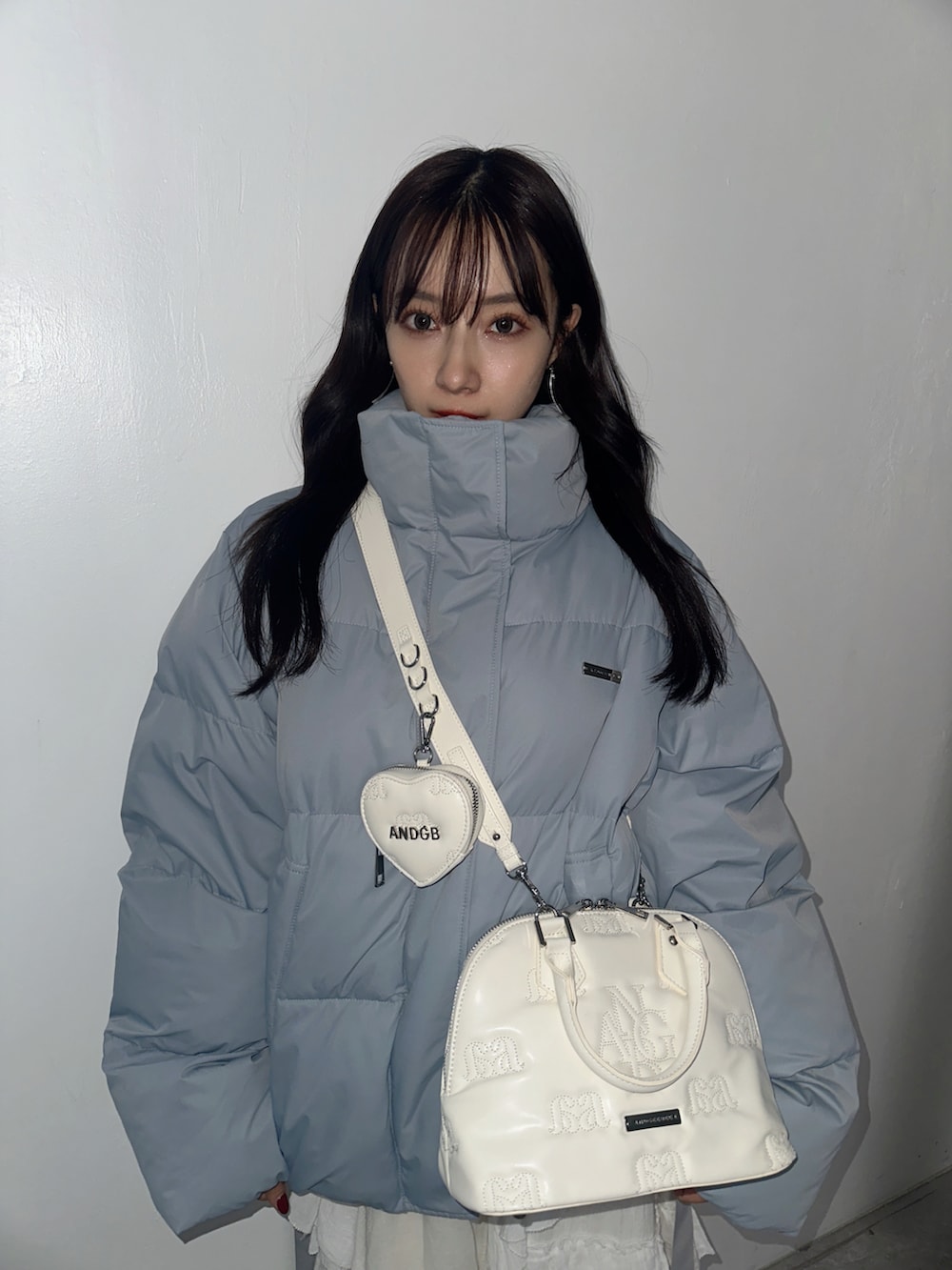 ホワイト系のスカート、グレー系のショルダーバッグ、ブルー系のダウンジャケット/コートを着用したレディースの春コーディネートの3枚目の写真